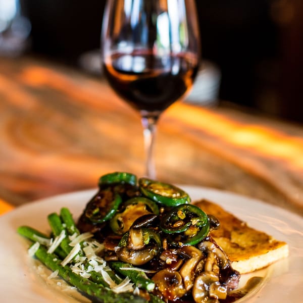 Unwined Kitchen & Bar's New American dish with steak, mushrooms, jalapeños, asparagus, and red wine.