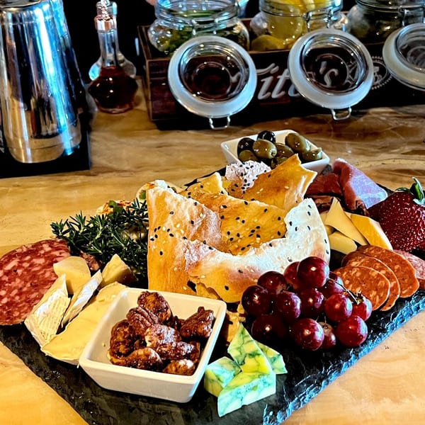 A charcuterie board with cheeses, meats, grapes, nuts, olives, and flatbread at Unwined Kitchen & Bar.