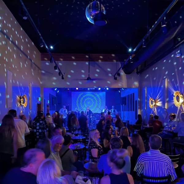 Unwined Kitchen & Bar's lively interior with a band performing on stage and patrons enjoying the music.