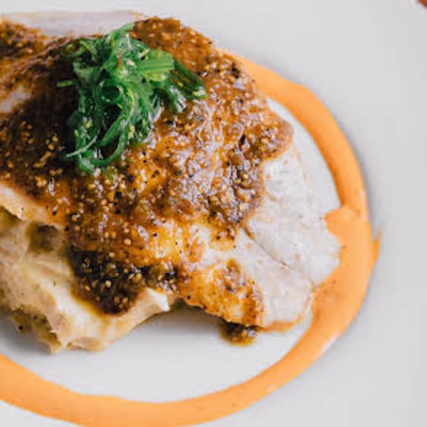 Unwined Kitchen & Bar's New American dish: a fish fillet topped with a rich sauce and fresh greens.