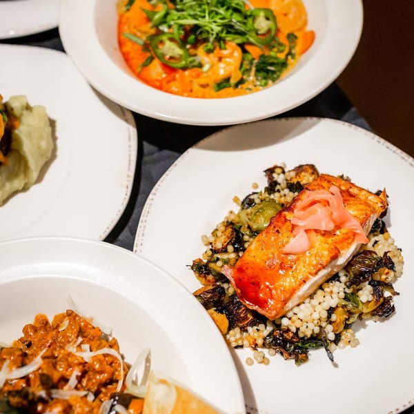 Unwined Kitchen & Bar's New American dishes: salmon with couscous, shrimp curry, and a stew.